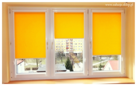 Żółte rolety okienne w kasecie z prowadnicami 